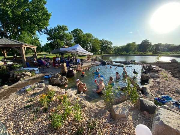 people swimming in pond built by Freedom Stone + Pondscapes