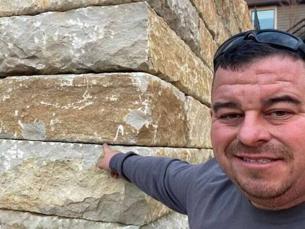 Bob Kerr, owner of Freedom Stone + Pondscapes, with a newly built stone retaining wall