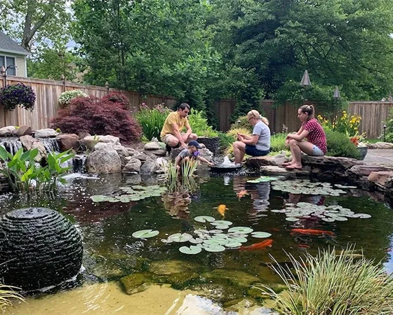 Family hanging around their koi pond