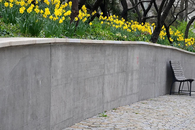 Poured concrete retaining wall along a walkway