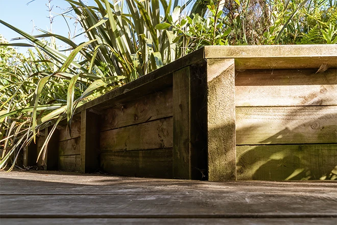 Short wood retaining wall creating a natural area
