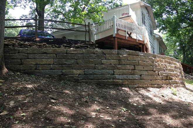 A retaining wall design for preventing erosion in front of a driveway