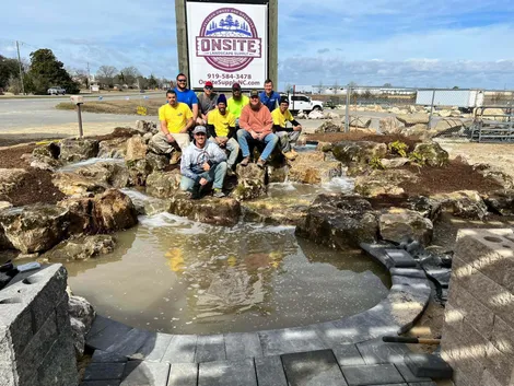 Construction team by a new stone water feature.
