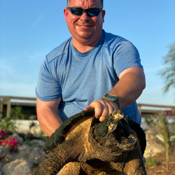 Bob Kerr, owner of Freedom Stone + Pondscapes, holding giant tortoise